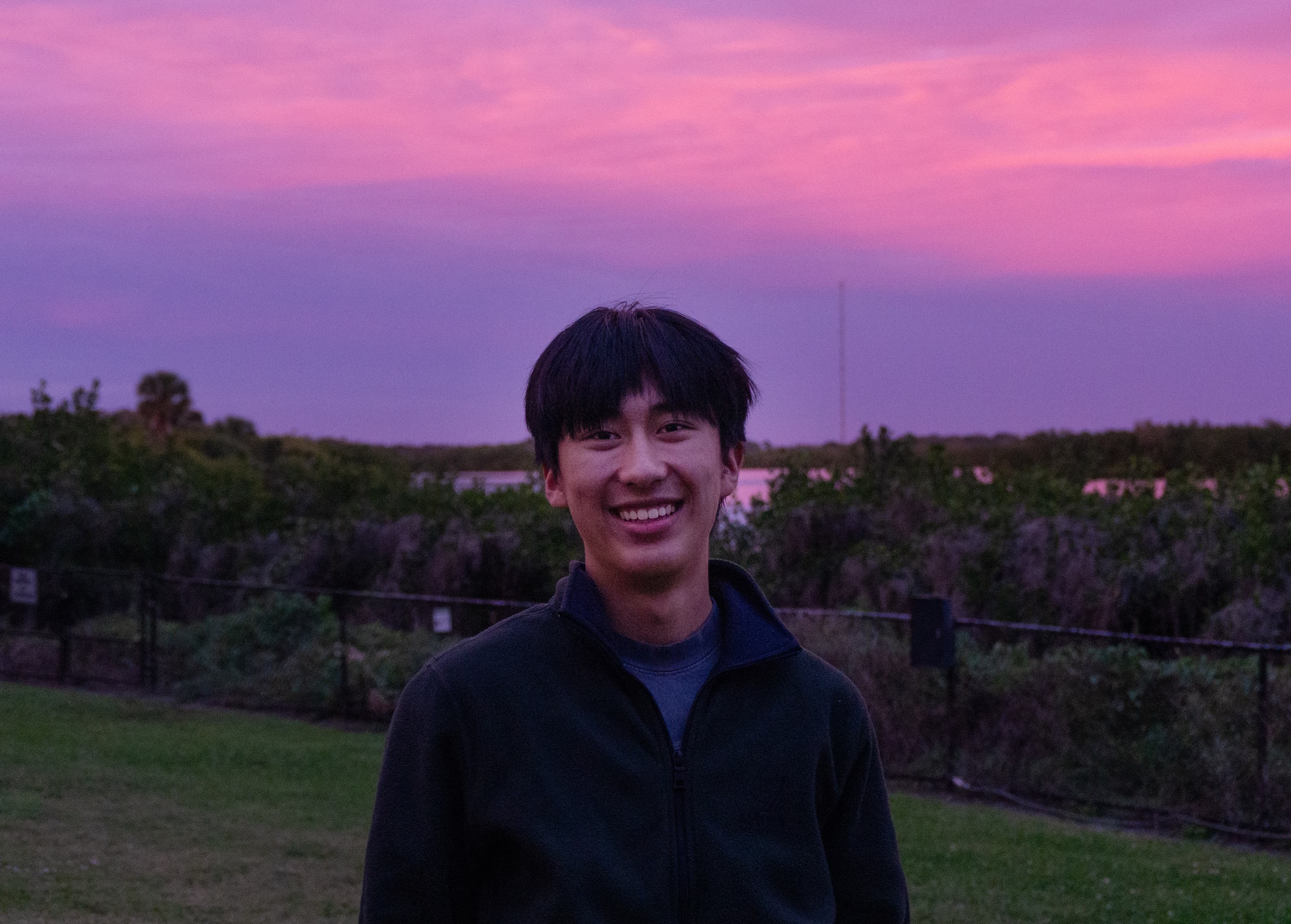 Caden smiling outdoors at sunset